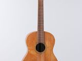 une petite guitare en bois accrochée à un mur blanc