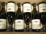 six bouteilles de vin sont posées sur une table dans un carton