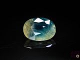 a close up of a blue and green gemstone on a black surface