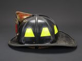 an old fireman ' s helmet with yellow eyes on it