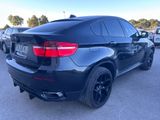 a black bmw suv parked in a parking lot next to other cars