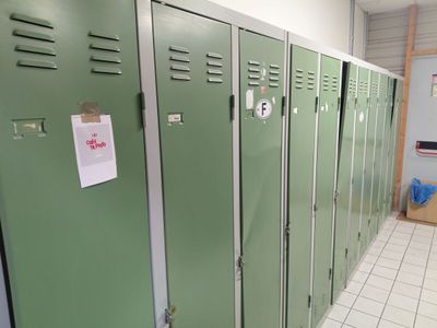 Plusieurs casiers verts sont alignés les uns à côté des autres dans une pièce