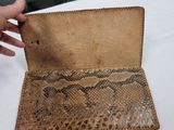 someone is holding a wallet that has a snake skin pattern on it