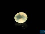 a close up of a yellow jade ball on a black surface