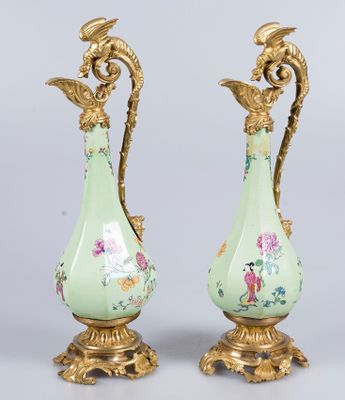 une paire de vases anciens ornés de motifs floraux, posés sur une table