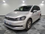 La Volkswagen Touran est garée dans une grande pièce au sol carrelé en damier.