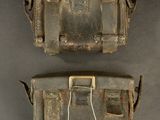 two pieces of old luggage sitting on top of a gray surface