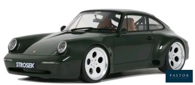 a green toy car that is sitting on a white surface
