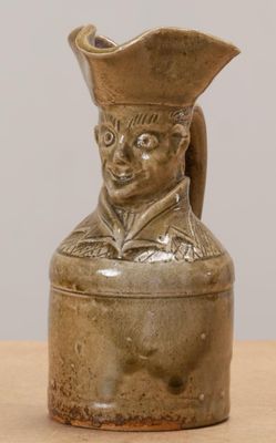 un petit vase sur lequel est représentée la statue d'un homme