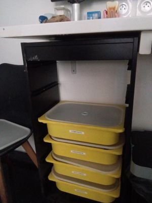 une pile de récipients en plastique posée sous un bureau