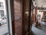a tall wooden cabinet in the corner of a room