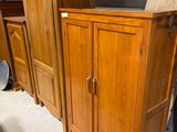 a wooden cabinet that is sitting in the middle of a room