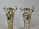 two silver vases sitting next to each other on a table
