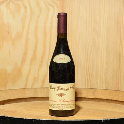 a bottle of wine sitting on top of a barrel