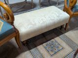 une banquette et des chaises rembourrées de couleur beige dans une pièce aux accents bleus et dorés