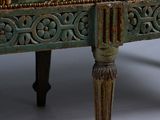 a green bench with a pattern on it on a white background