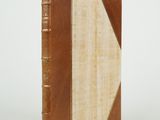 an old book sitting on top of a white table next to a white wall