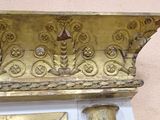a clock on the wall with gold decorations on it