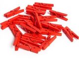 many red clothes pegs on a white surface