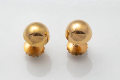 une paire de boucles d'oreilles plaquées or sur un fond blanc