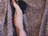un homme nu debout sur une couverture à motif léopard