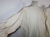two coats on a mannequin on a white wall