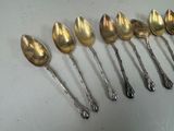 six silver spoons are lined up in a row on a table
