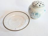 une assiette blanche et un ensemble de sel et de poivre bleu et blanc posés sur une table blanche
