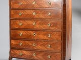 une commode ancienne avec un plateau en bois et des poignées en laiton