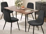 une table à manger avec quatre chaises et une corbeille de fruits posée dessus