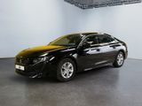 La voiture noire est garée dans la grande salle du bâtiment.