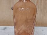 a glass bottle with a black top sitting on a table