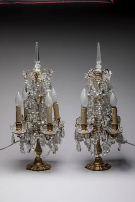 paire de bougeoirs en cristal et en laiton posés sur un socle