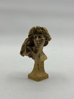 une statue en bronze d'une femme avec un chapeau sur la tête