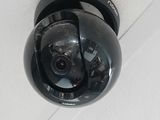 a black camera mounted on the ceiling of a building