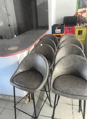 quatre chaises disposées devant un comptoir dans un restaurant