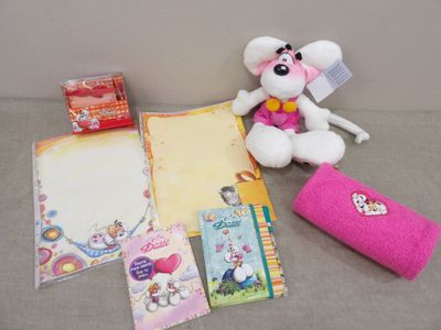 a teddy bear sitting next to a bunch of stationery items