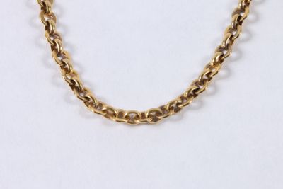 a close up of a gold chain necklace on a white background