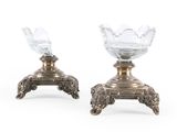 paire de bougeoirs en métal argenté avec des vases en cristal taillé posés sur des socles
