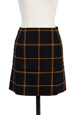 une jupe à carreaux noirs et orange sur un mannequin, un mannequin, un mannequin, un mannequin, un mannequin, un mannequin, un mannequin, un mannequin