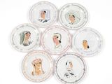 several plates with different designs of people on them on a white surface