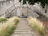 un escalier menant à un bâtiment en pierre, avec un arbre au premier plan