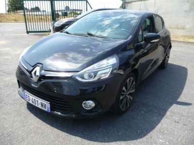 La voiture noire est garée sur le parking, à côté d'une clôture.
