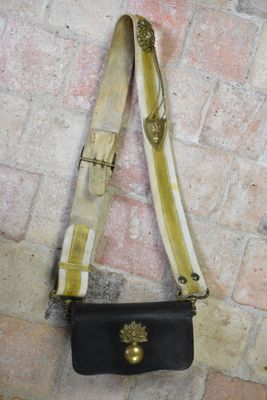 a black purse hanging on a brick wall next to a brick floor