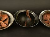 three helmets are lined up in a row on a black surface