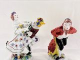 two figurines of a man and a woman dressed in costumes