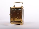 a small gold clock sitting on top of a white table