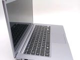 a silver laptop with a black keyboard on a white surface
