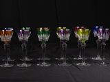 seven wine glasses lined up in a row on a table
