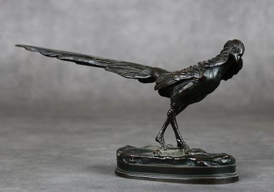 une statue représentant un oiseau posé sur un socle